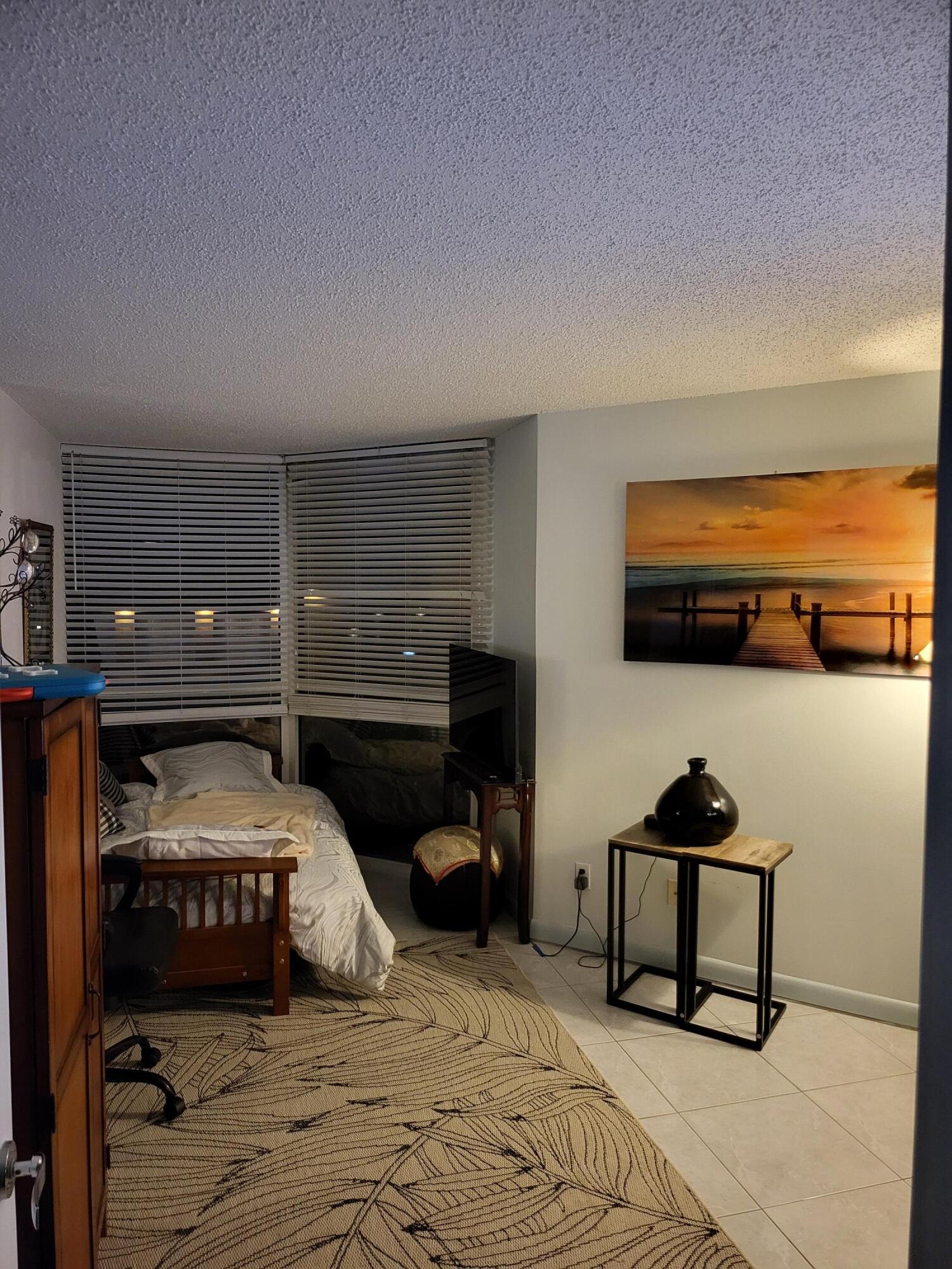 3870 North Hwy A1A, Unit 1011 Hutchinson Island, FL 34949 - Photo 17 of 30 a bedroom with a bed and a lamp