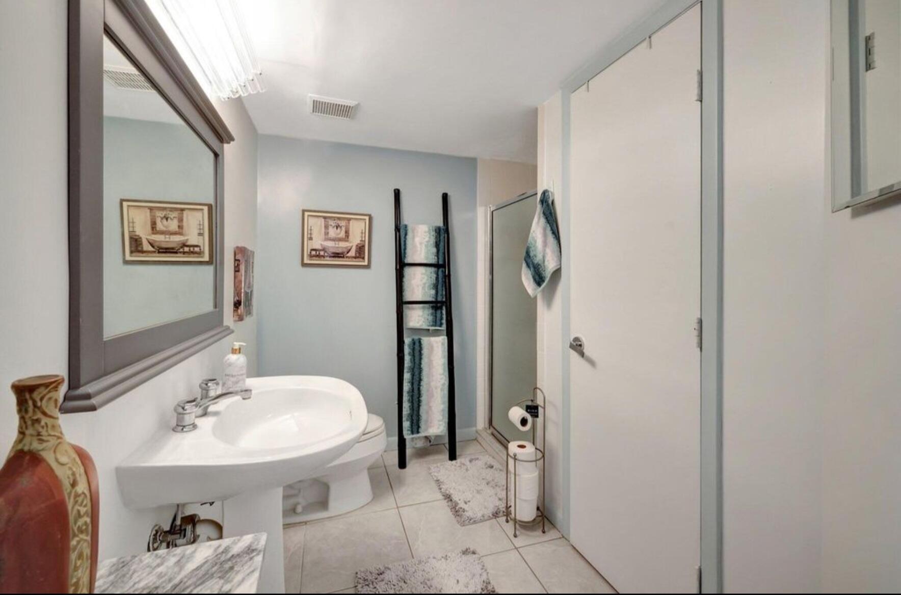 3870 North Hwy A1A, Unit 1011 Hutchinson Island, FL 34949 - Photo 18 of 30 a bathroom with a sink and mirror