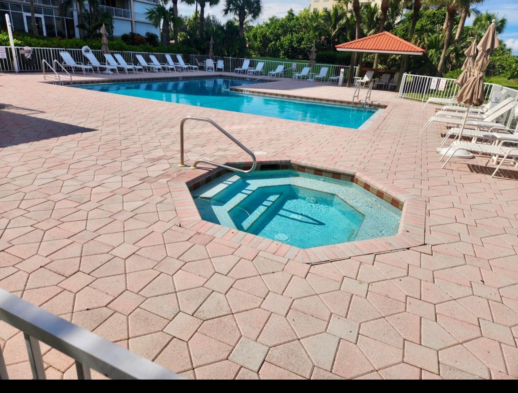 3870 North Hwy A1A, Unit 1011 Hutchinson Island, FL 34949 - Photo 19 of 30 a view of a swimming pool with a patio