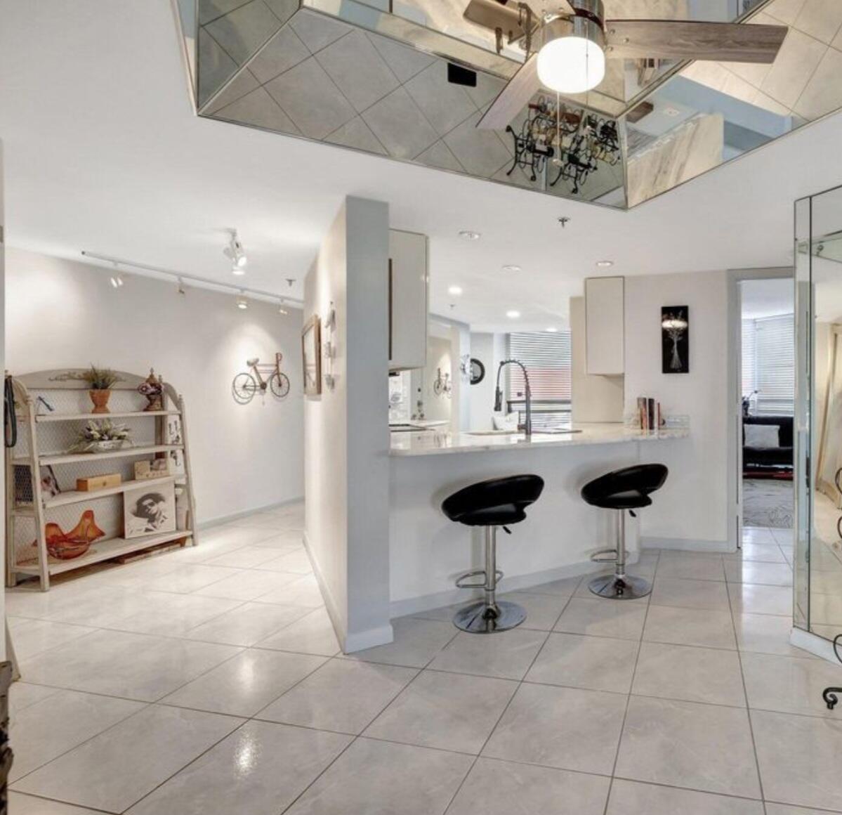 3870 North Hwy A1A, Unit 1011 Hutchinson Island, FL 34949 - Photo 4 of 30 a kitchen with stainless steel appliances kitchen island granite countertop a sink and a black cabinets