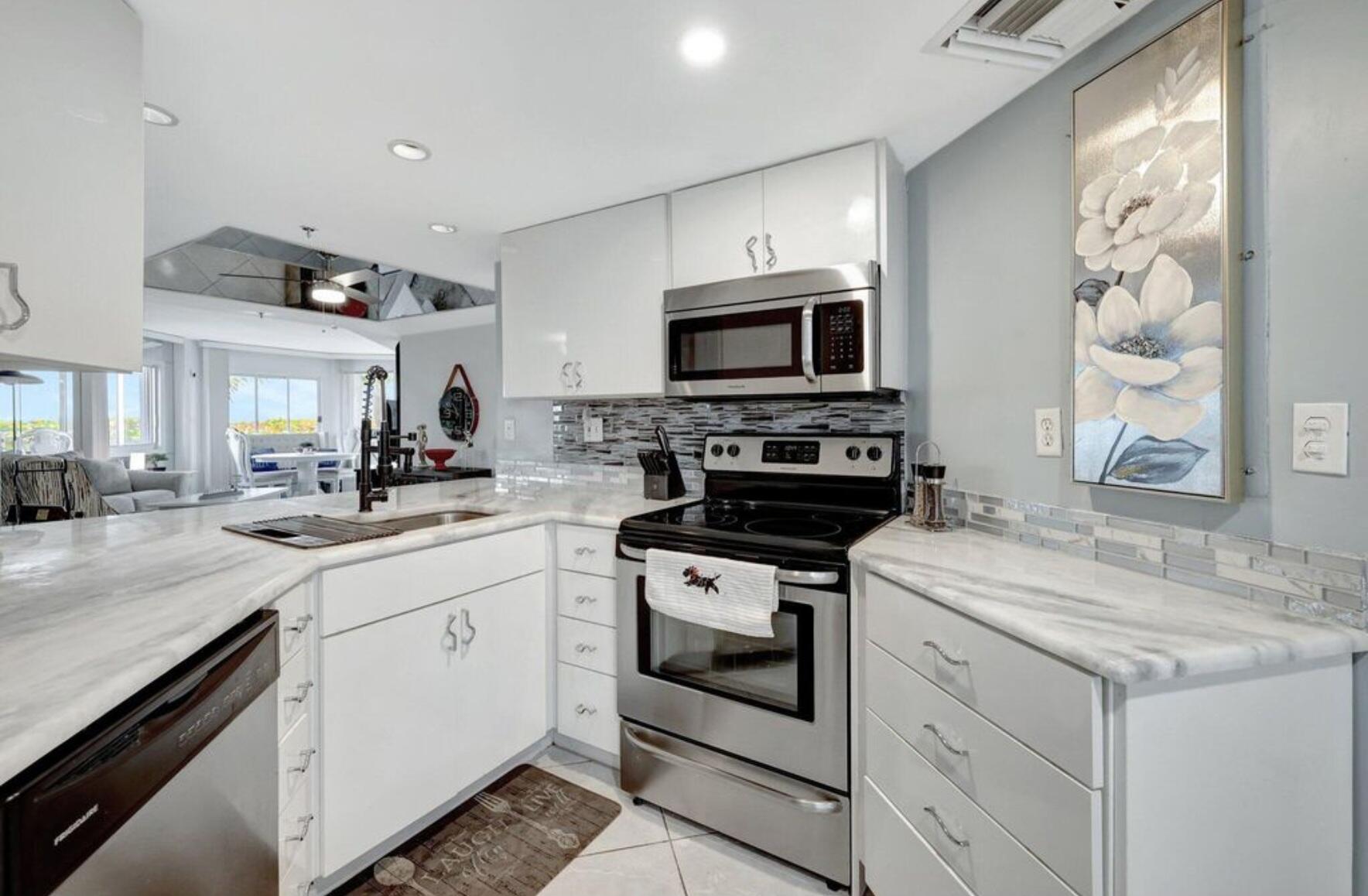 3870 North Hwy A1A, Unit 1011 Hutchinson Island, FL 34949 - Photo 6 of 30 a kitchen with a sink stove and microwave