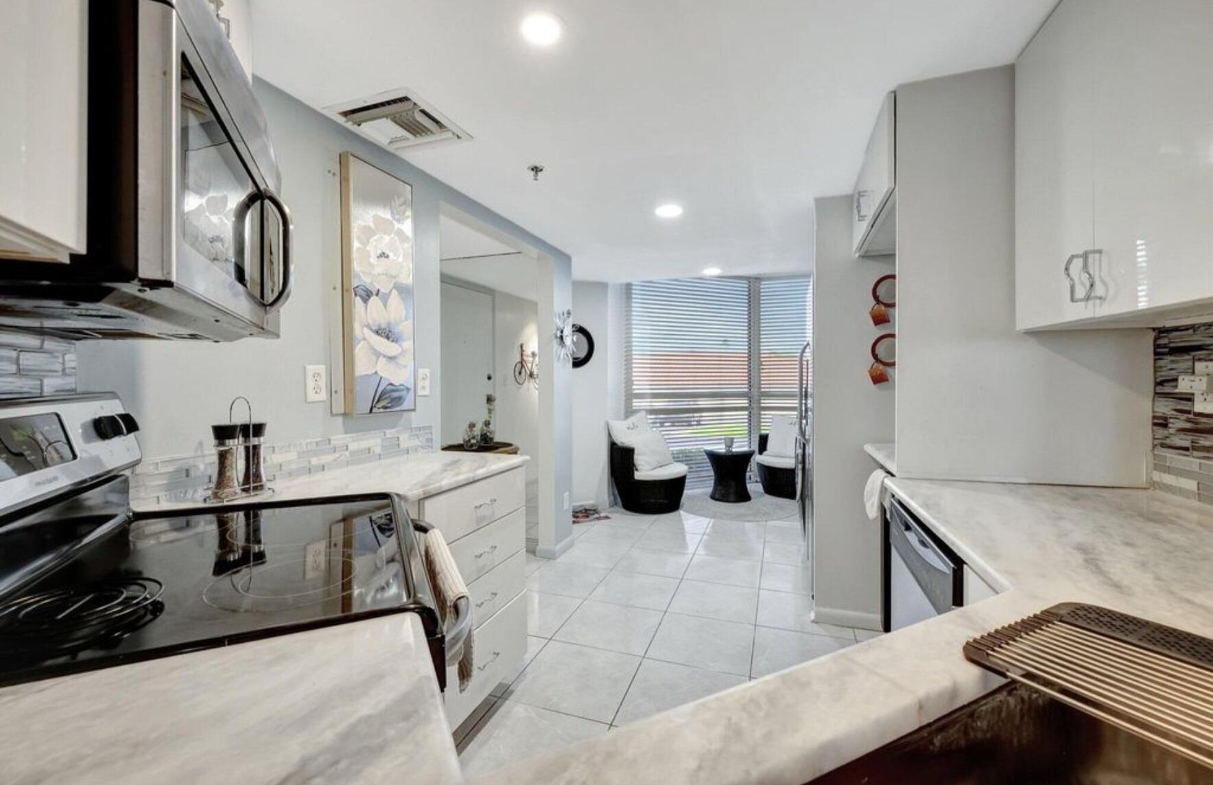 3870 North Hwy A1A, Unit 1011 Hutchinson Island, FL 34949 - Photo 7 of 30 a kitchen with stainless steel appliances granite countertop a sink and cabinets
