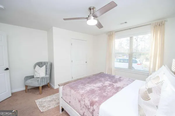 a bedroom with a bed chair and window