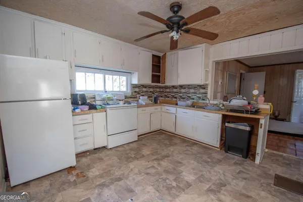 a kitchen with white cabinets and white appliances