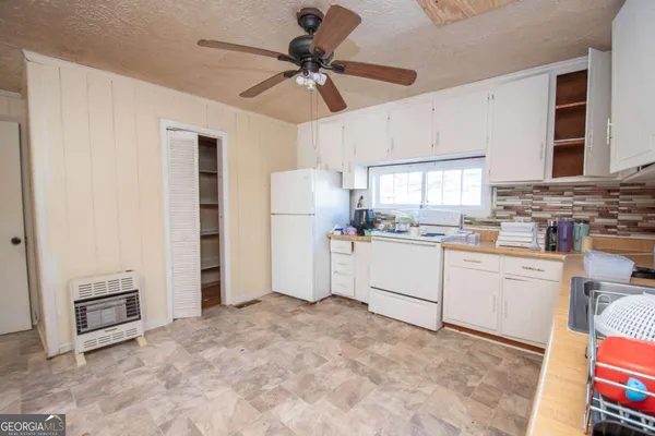 a kitchen with white cabinets and white appliances
