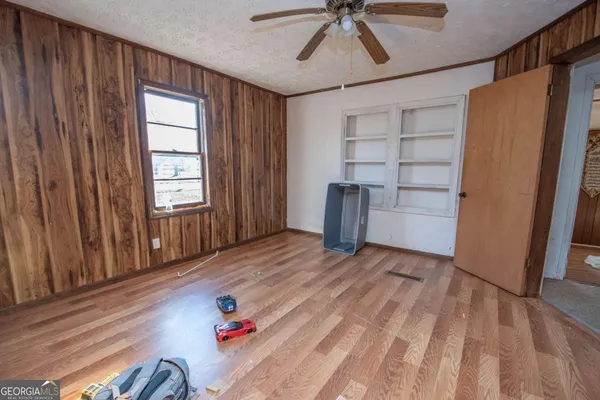 a view of empty room with cabinet and window