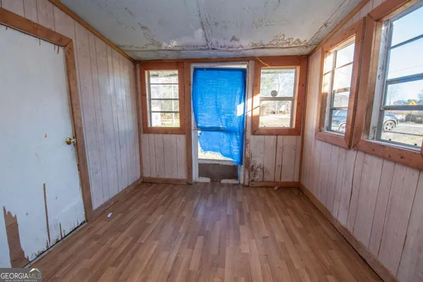 a view of empty room with wooden floor and fan