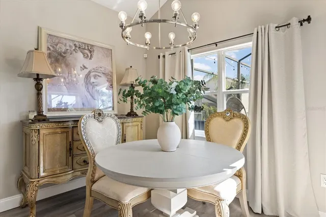 a dining room with furniture potted plants and wooden floor