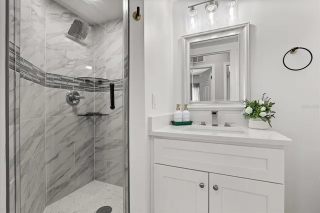 a bathroom with a shower sink and mirror