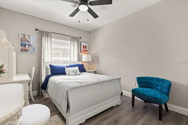 a bedroom with a bed a couch and a potted plant