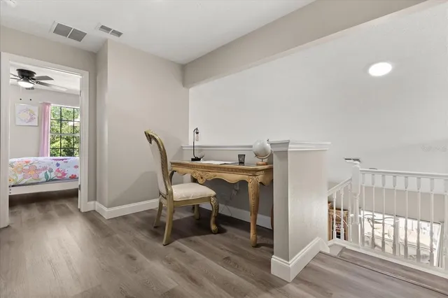 a view of a room with wooden floor furniture and windows