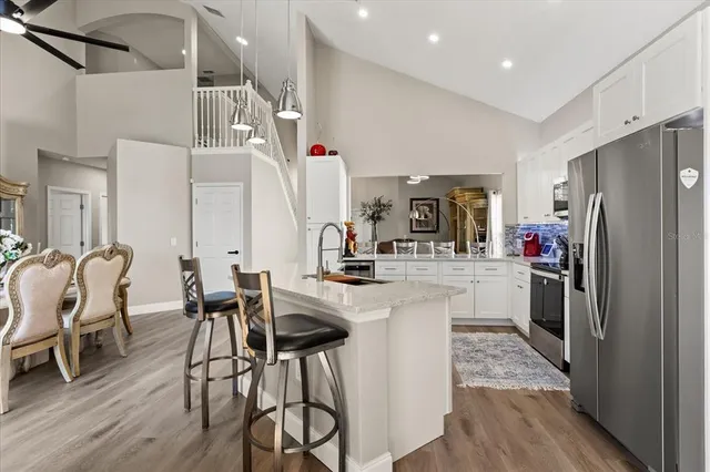 a kitchen with stainless steel appliances a dining table chairs and a refrigerator