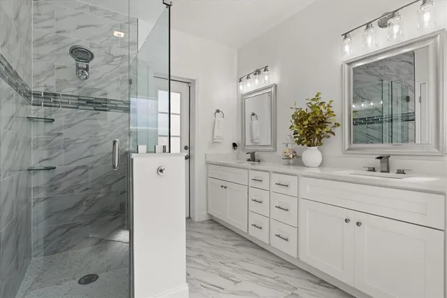 a bathroom with a double vanity sink mirror and shower