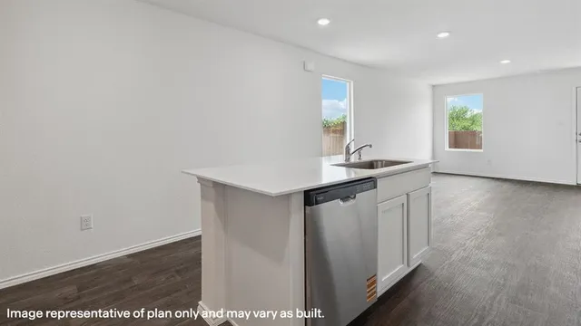 a kitchen with a sink and wooden floor