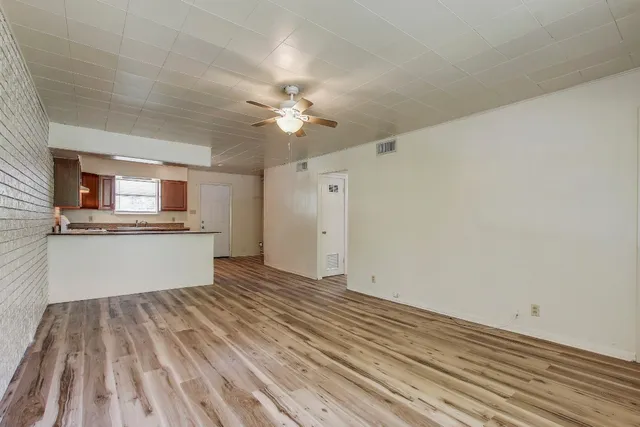 wooden floor in an empty room with a kitchen