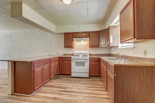 a kitchen with a stove sink and cabinets