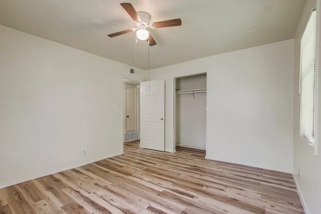 a view of a livingroom with wooden floor and a ceiling fan