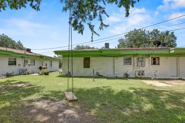 a backyard of a house with table and chairs