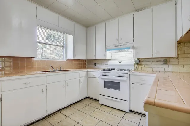 a kitchen with granite countertop white cabinets and white appliances