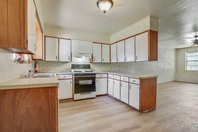 a kitchen with granite countertop white cabinets and white appliances