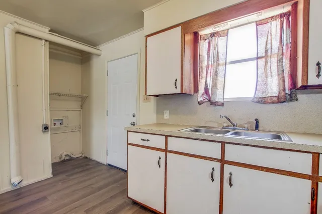 a kitchen with a sink cabinets appliances and a window