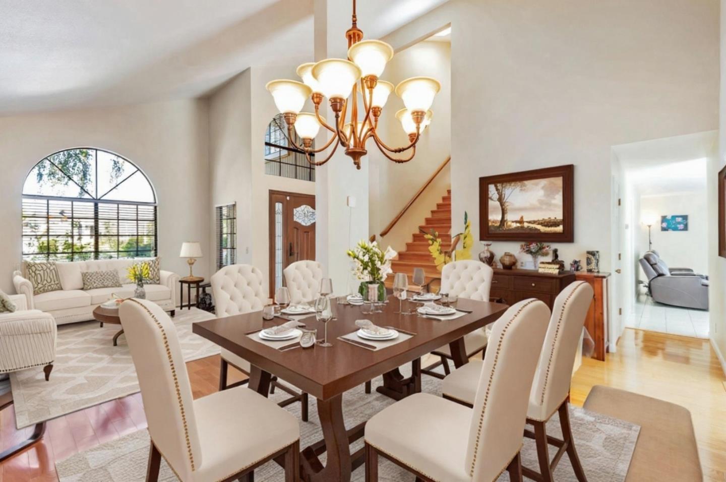 a view of a dining room with furniture a chandelier and a large window