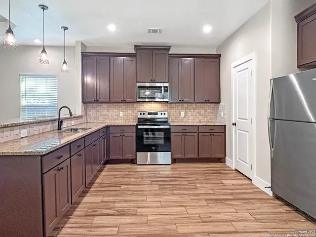a kitchen with kitchen island a sink a counter top space stainless steel appliances and cabinets