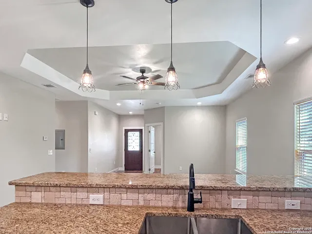 a view of a kitchen with a sink chandelier and refrigerator