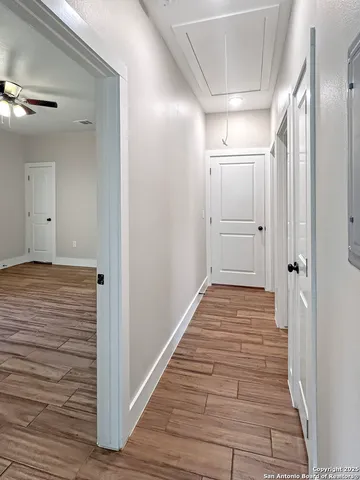 a view of a hallway with wooden floor and staircase
