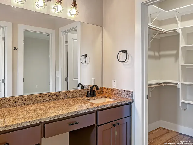 a bathroom with a granite countertop sink and a mirror