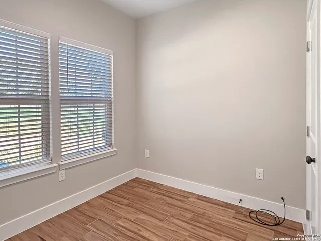 a view of a room that has wooden floor and a window