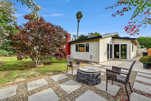 a view of a chairs and table in backyard of the house
