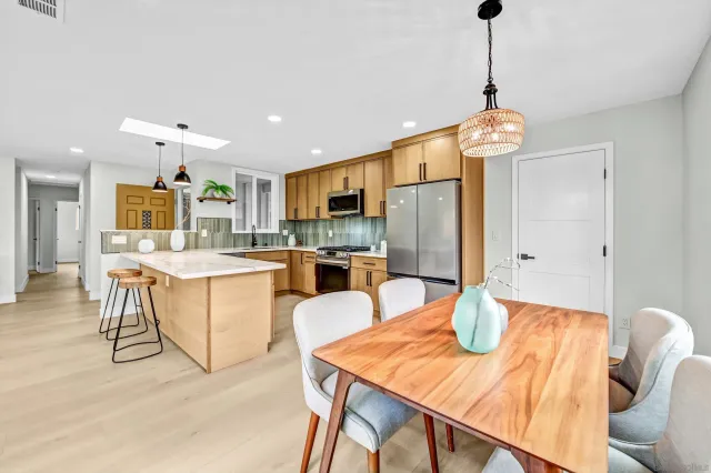 a view of a dining room and livingroom with furniture wooden floor a chandelier