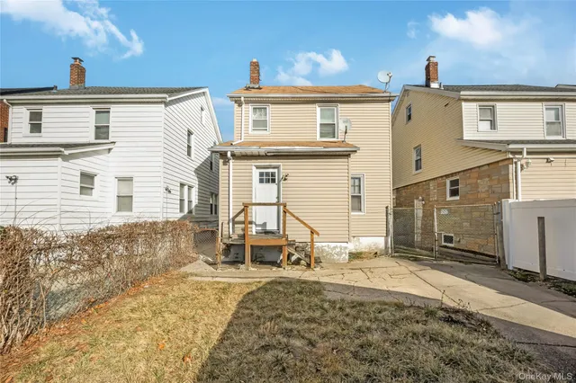 a view of a house with a barbeque and wooden stairs