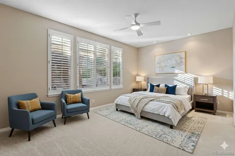 a spacious bedroom with a bed a couch and a chandelier