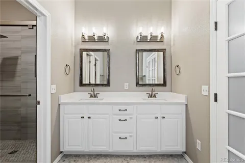 a bathroom with double sink and a mirror