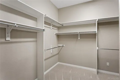 a view of walk in closet with empty racks