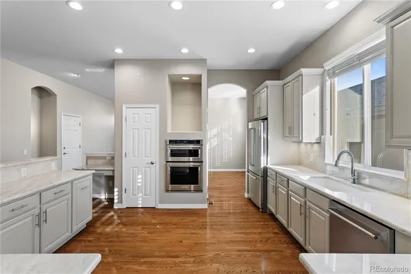 a large kitchen with a large counter top stainless steel appliances and cabinets