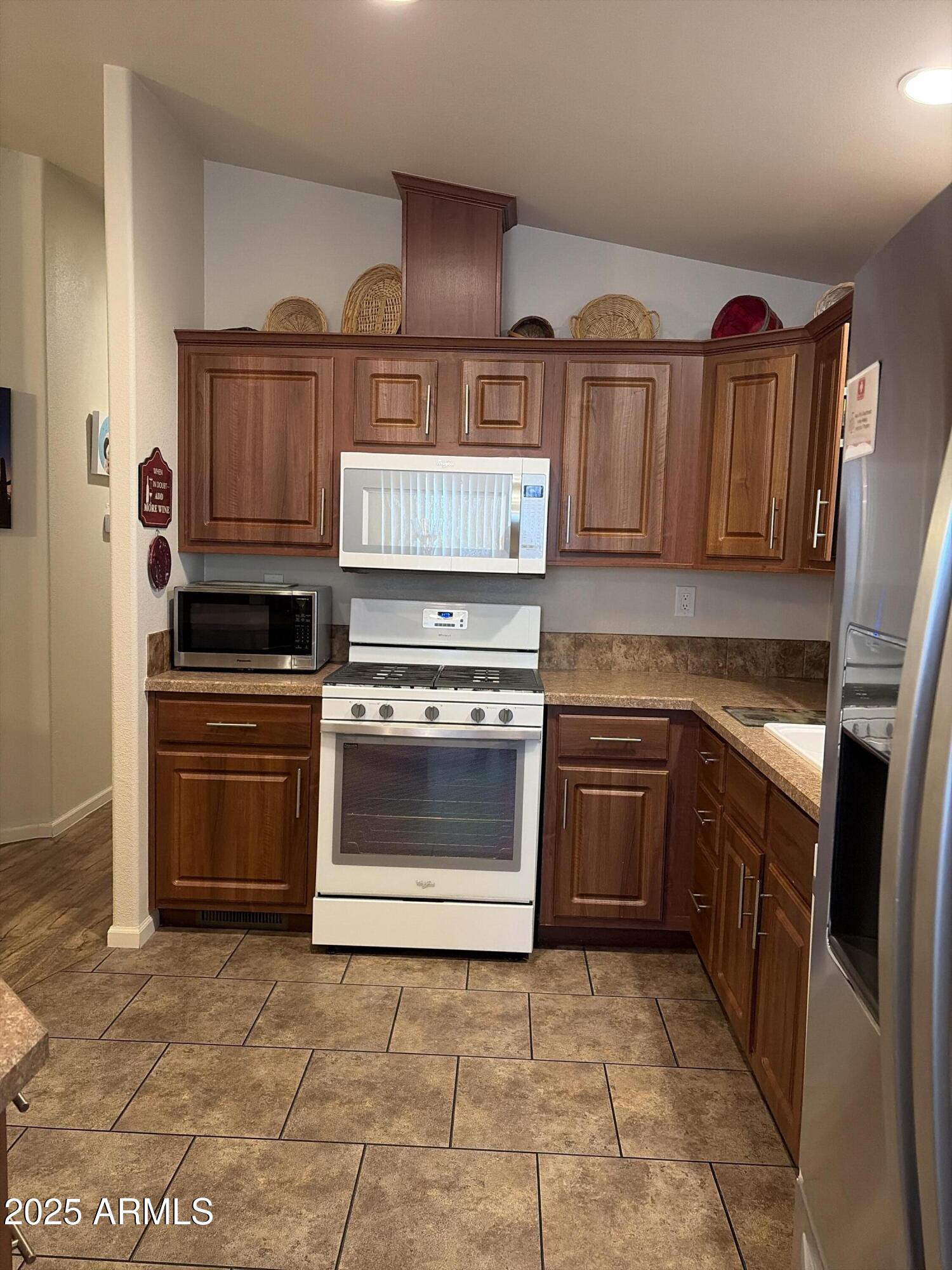 2929 East Main Street, Unit 43 Mesa, AZ 85213 - Photo 12 of 36 a kitchen with granite countertop a stove top oven and cabinets