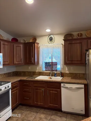 a kitchen with stainless steel appliances granite countertop a refrigerator and a sink