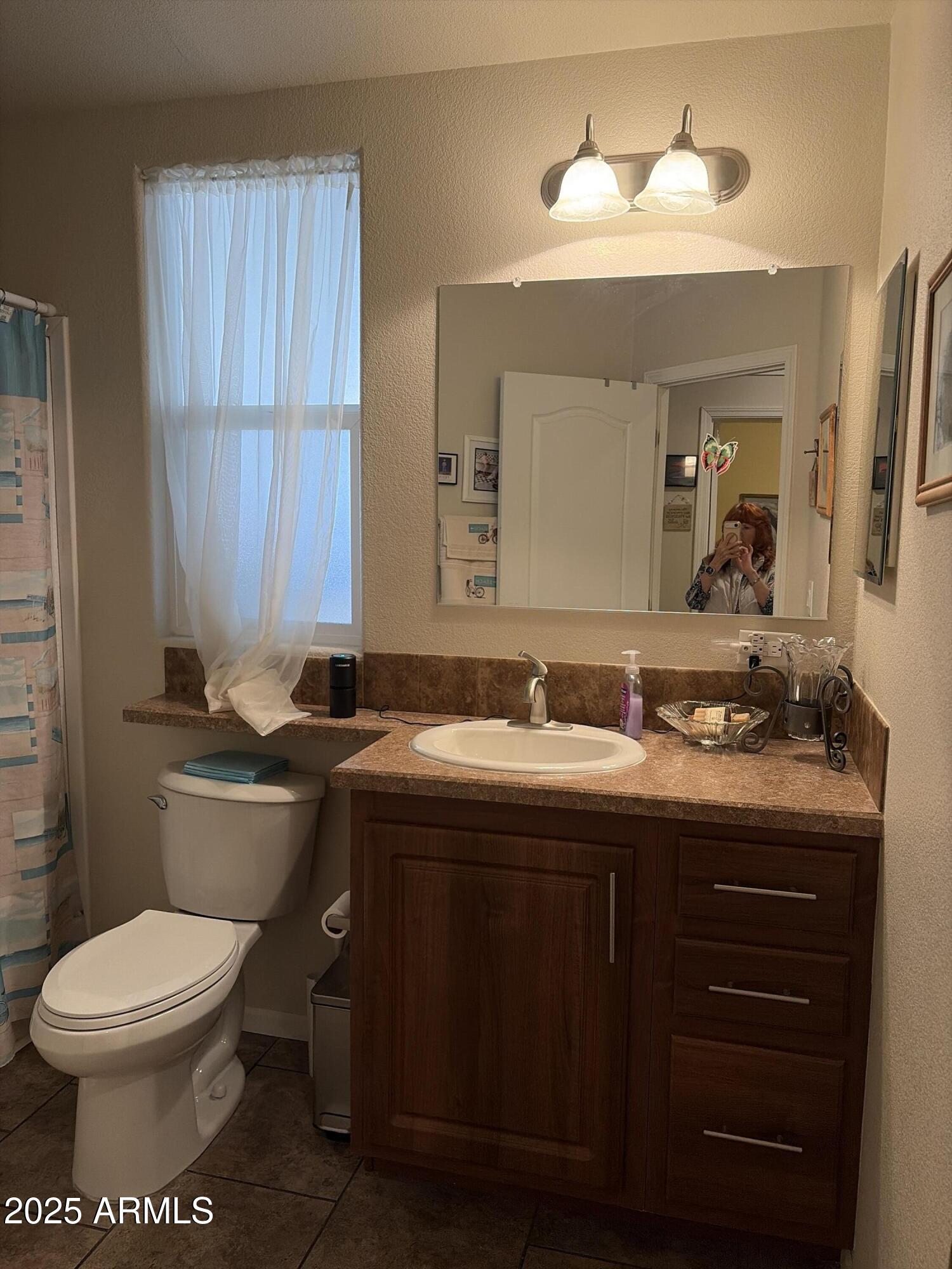 2929 East Main Street, Unit 43 Mesa, AZ 85213 - Photo 32 of 36 a bathroom with a toilet sink and mirror
