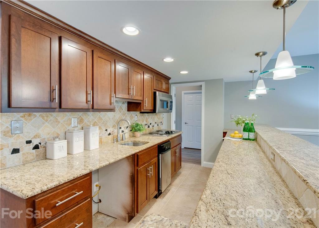 2314 Mermans Road Charlotte, NC 28270 - Photo 34 of 45 a kitchen with stainless steel appliances granite countertop a sink a stove and a wooden floors