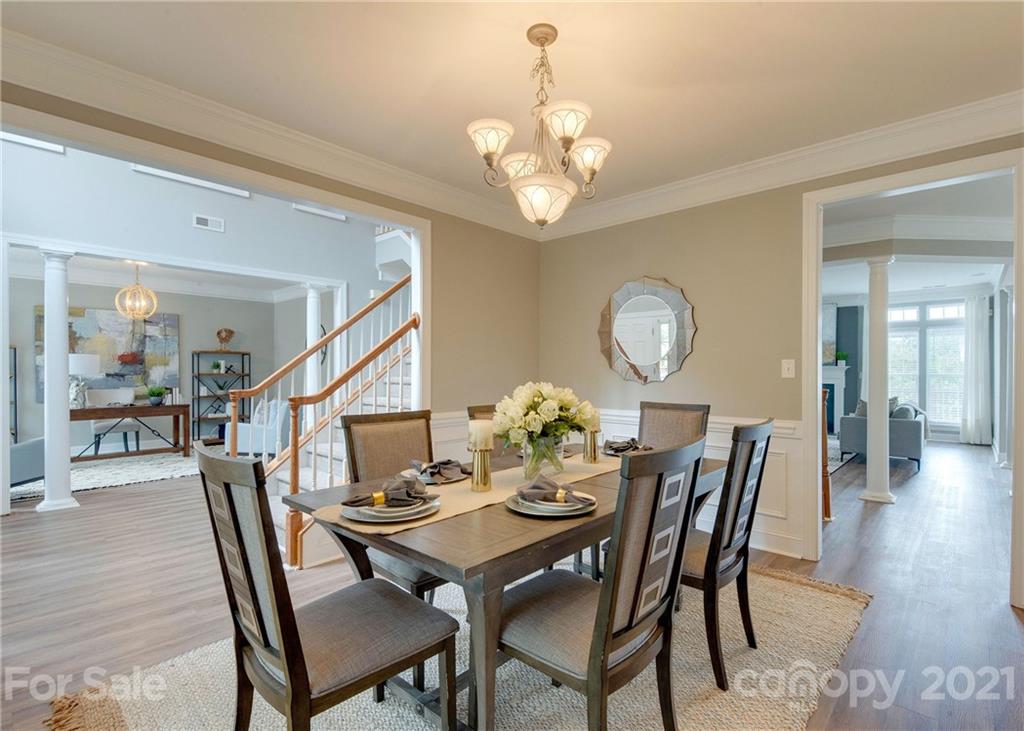 2314 Mermans Road Charlotte, NC 28270 - Photo 6 of 45 a dining room with wooden floor a chandelier a wooden table and chairs