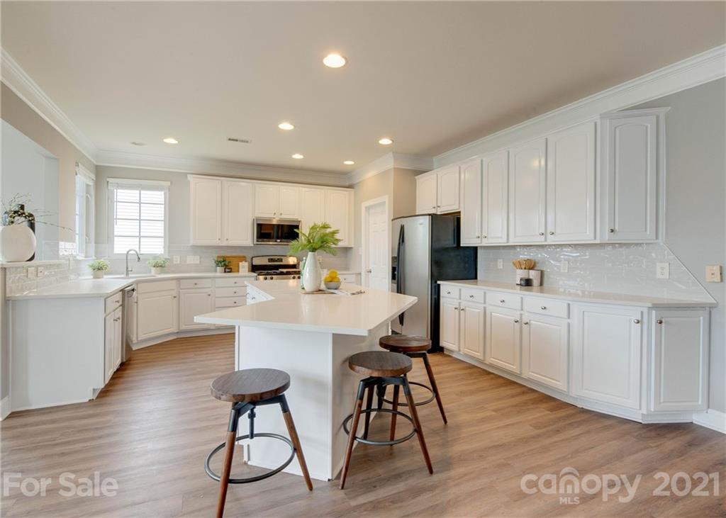 2314 Mermans Road Charlotte, NC 28270 - Photo 9 of 45 a kitchen with white cabinets and stainless steel appliances