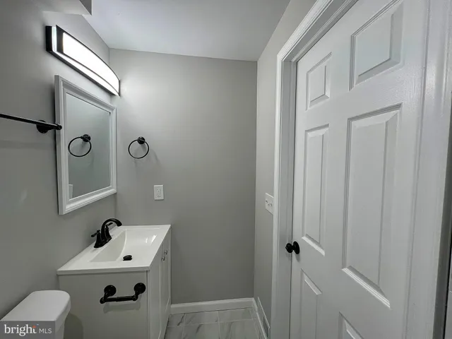 a bathroom with a sink mirror and toilet