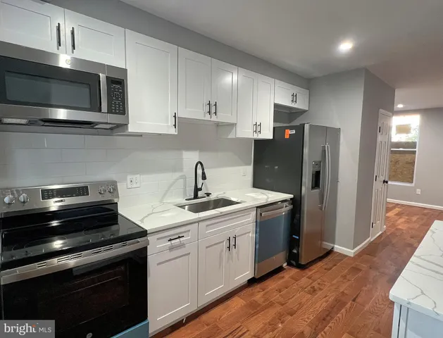 a kitchen with kitchen island stainless steel appliances a stove refrigerator and microwave