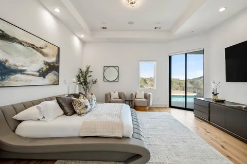 a bedroom with furniture and a large window