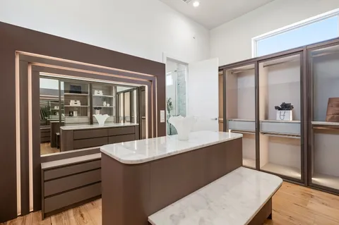 a living room with stainless steel appliances kitchen island granite countertop a refrigerator and wooden cabinets