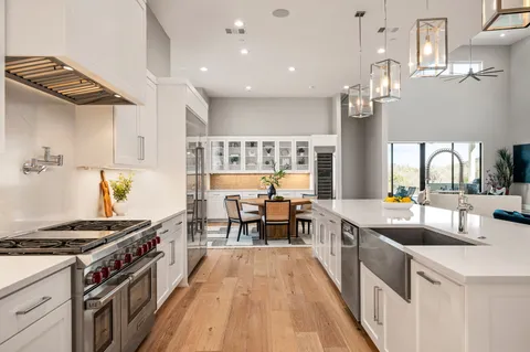 a kitchen with stainless steel appliances a sink a stove top oven a chimney and a center island