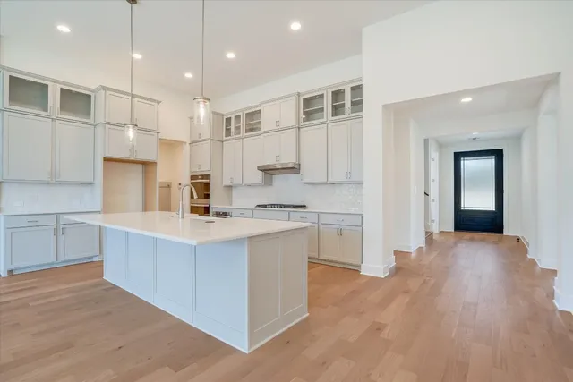 a large kitchen with kitchen island a sink stainless steel appliances and cabinets